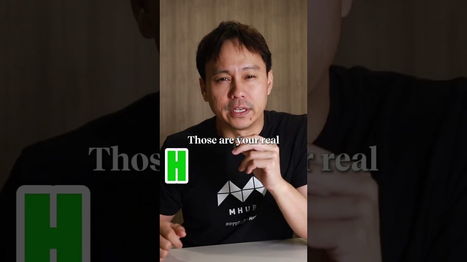 A presenter in a black MHub t-shirt talking to camera, with the on-screen caption "Those are your real" and a green letter tile starting the next word.